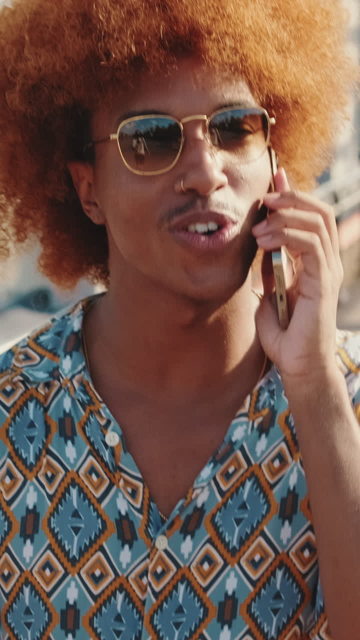 Giovane uomo felice che parla al telefono all'aperto