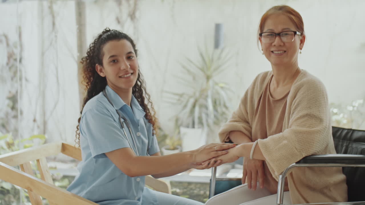 Caregiver supporting a senior woman in a wheelchair