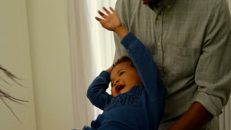 primer plano de jóvenes padres negros jugando y sosteniendo a su hijo en una casa cómoda 4k