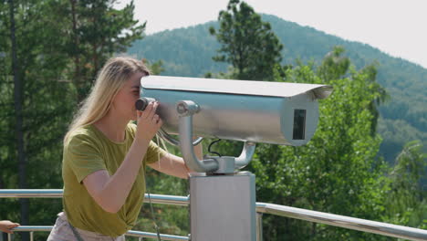 woman tourist looks through tower viewer on observation deck