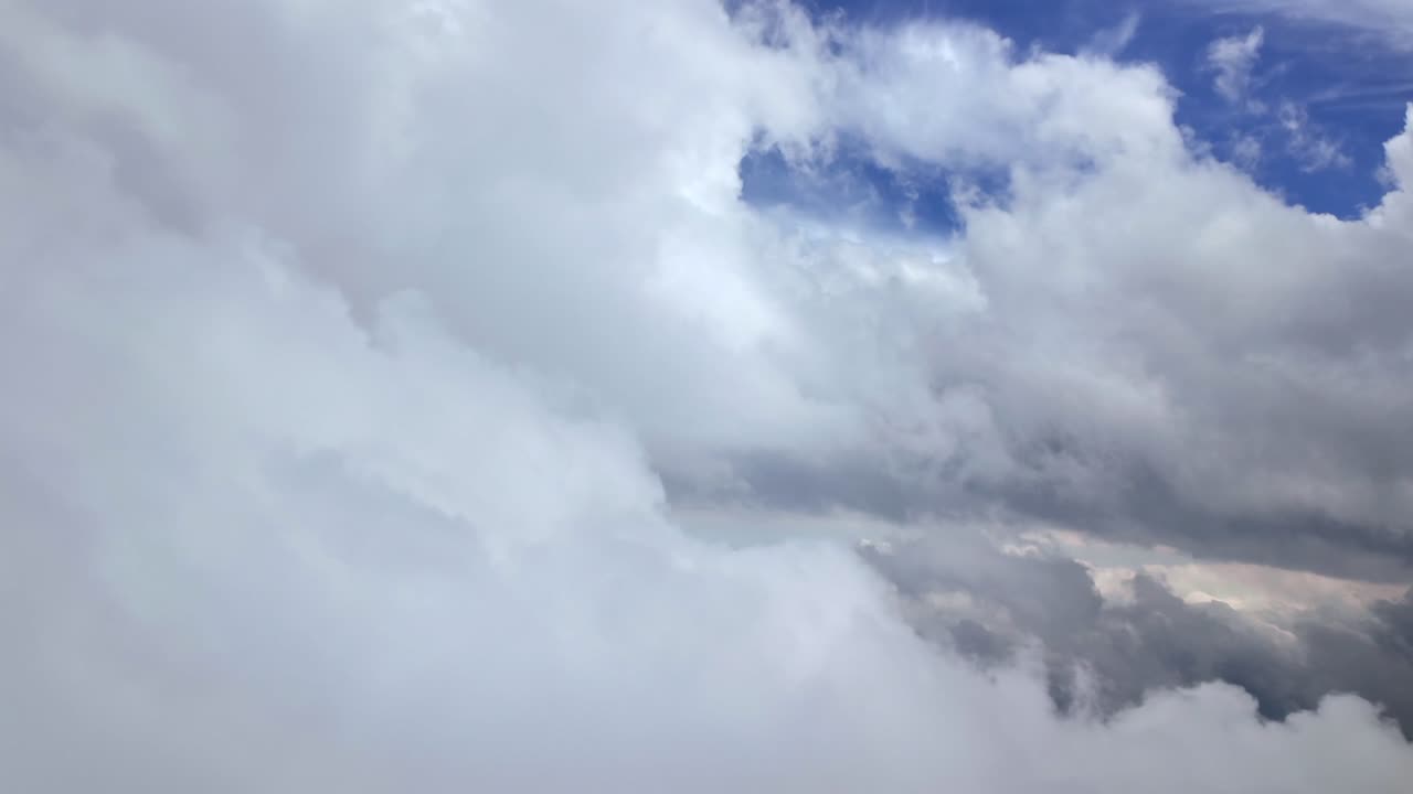an immersive view through the pilot’s eyes from a jet cockpit flying through a dreamy cloudscape full of white storm cumulus. 4K