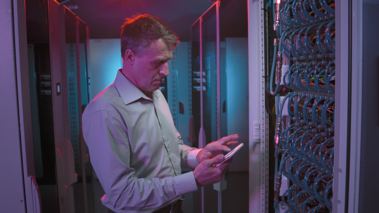 Male Technician Checking Servers in Data Center