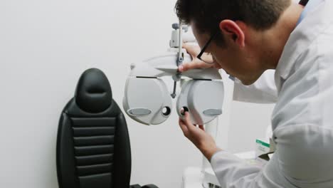 Smiling-optometrist-adjusting-phoropter