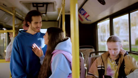 una pareja hablando en el autobús.