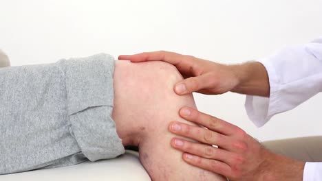 el médico tocando la rodilla de los pacientes mayores.