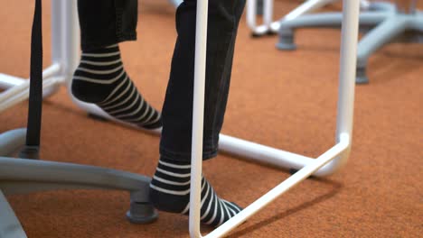 childs feet in black white striped socks swinging feet under desk