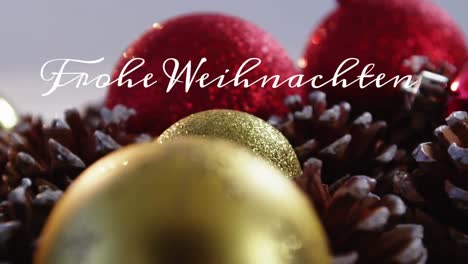 animation of german greeting text over christmas bauble and pine cones decorations