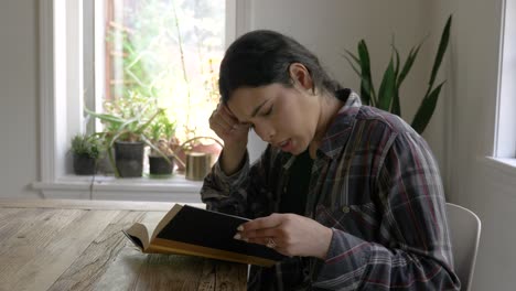 focused expression puerto rican female teenager sitting reading inspirational positive emotion book in home interior