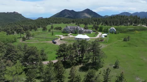 drone fly over woodland to luxury mansion located in mountains