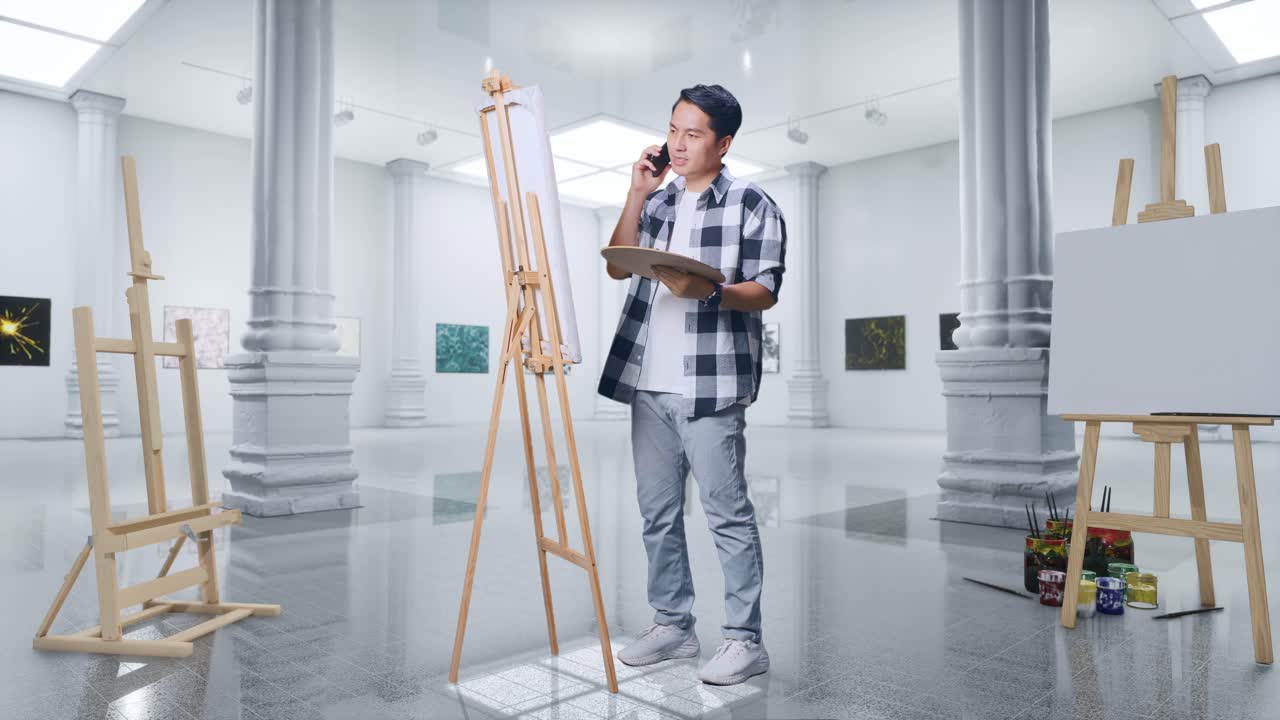 갤러리에서 오일 페인트와 으로 캔버스에 그림을 그리는 동안 스마트폰으로 이야기하는 아시아 남성 예술가의 몸이 가득 차 있습니다.
