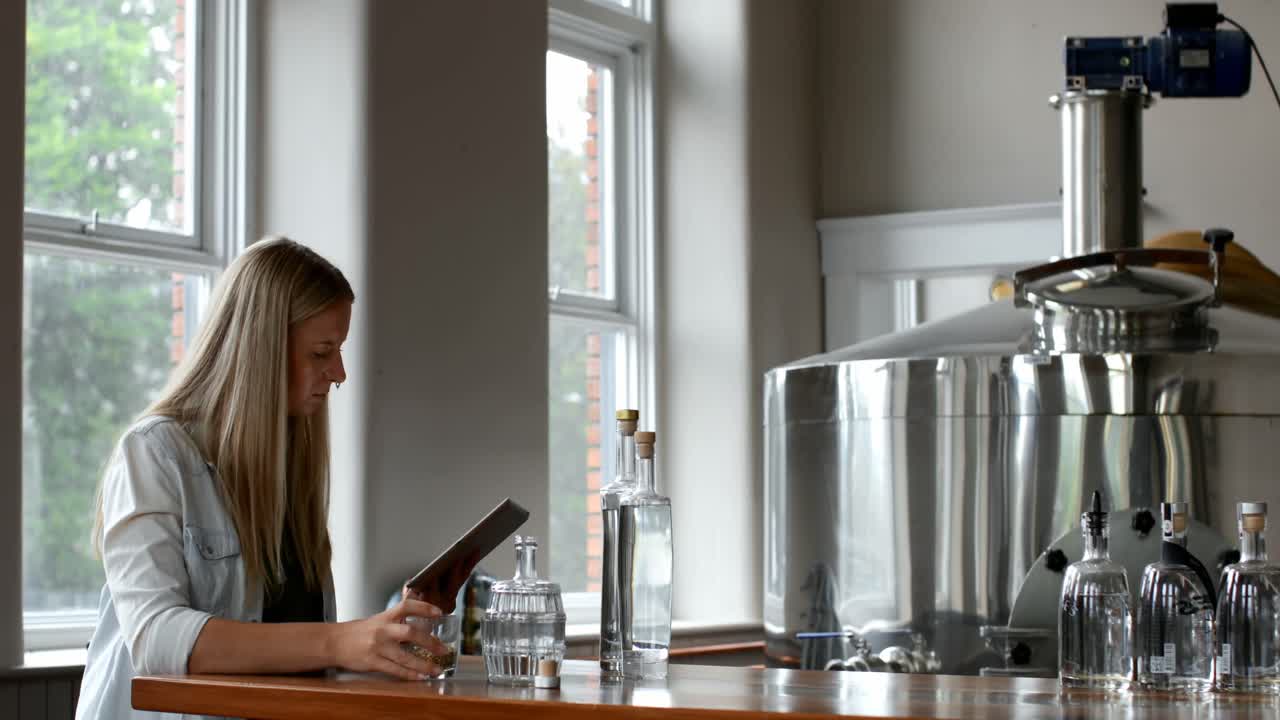 증류 공장에서 디지털 태블릿을 사용하는 여성 노동자 4k