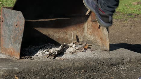 el hombre patea la parte superior de la barbacoa caliente con su zapato