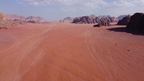 Aerial-view-of-two-cars-driving-through-the-amazing-Wadi-Rum-desert-in-Jordan