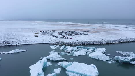 icebergs floating in the jökulsárlón glacial lagoon, vatnajökull national park, south coast of iceland - aerial pullback