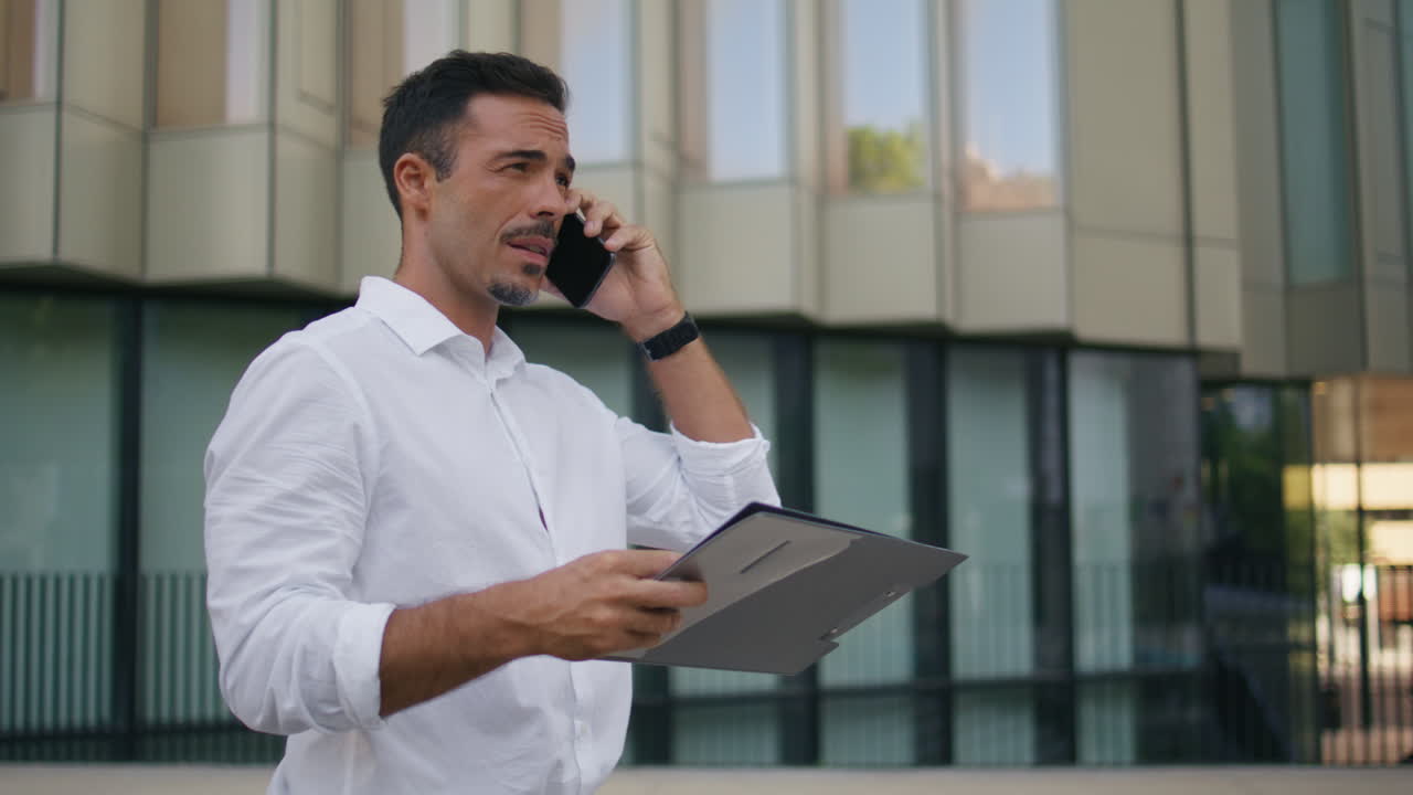 Relaxed boss talking phone call walking business building background closeup