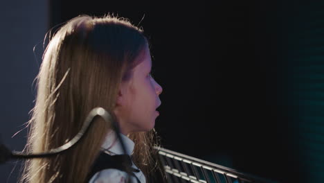 warm-up exercises before singing closeup. small child engages in articulating gymnastics in recording studio. professional techniques for better sound