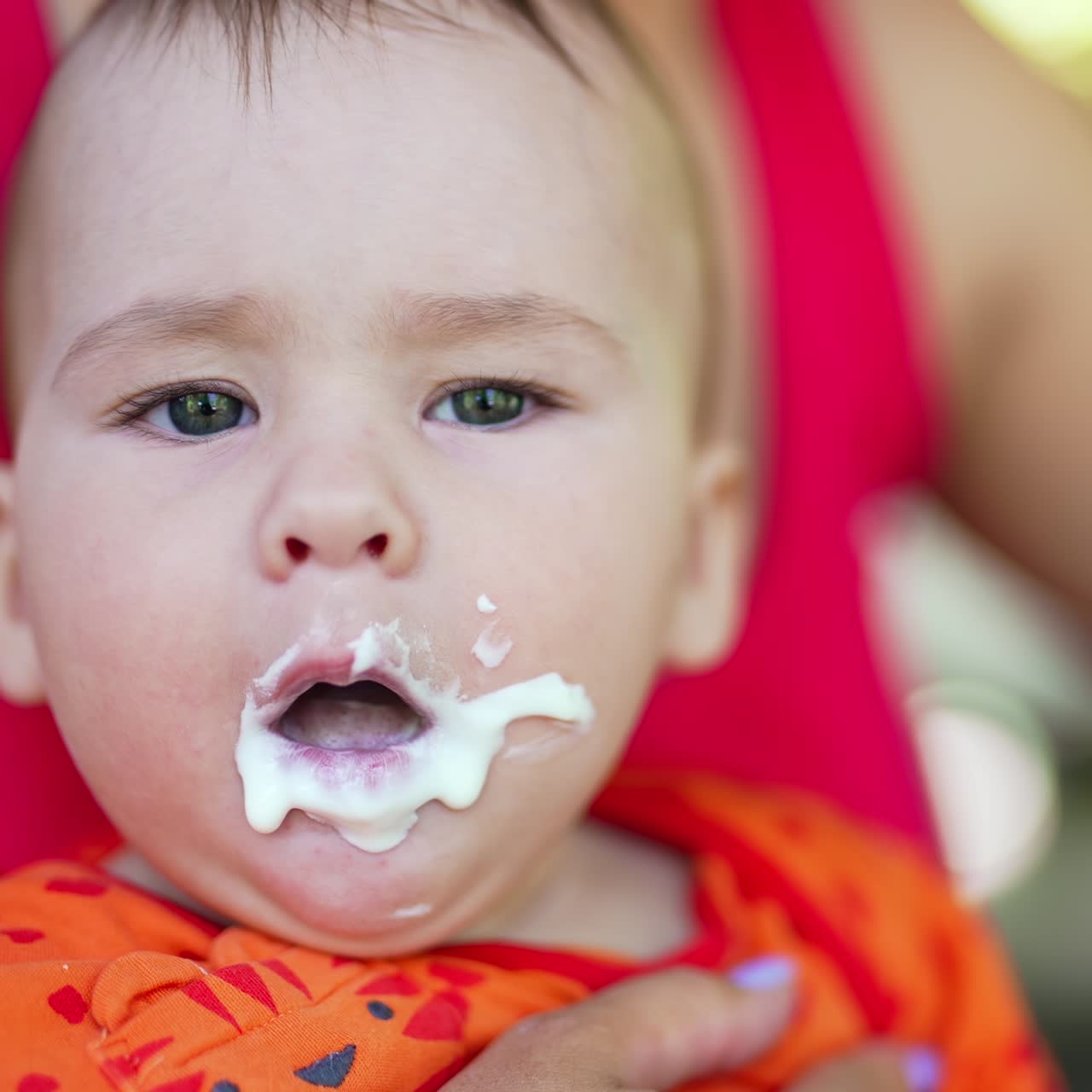Sweet child opens mouth wide to the full spoon. Beautiful baby closes eyes disliking food and coughs. Close up