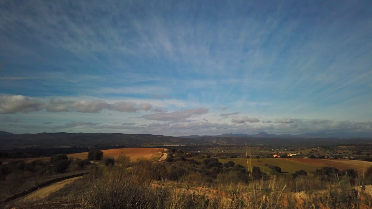 un lapso de movimiento de algunos montículos arados bajo nubes ligeras que se mueven a la derecha