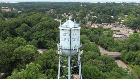 An-aerial-view-of-a-water-tower-in-a-suburban-neighborhood-on-Long-Island,-NY-on-a-cloudy-day