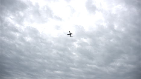 Flugzeug-Flugzeug-Von-Unten-Gesehen,-Das-An-Einem-Kühlen-Tag-Durch-Einen-Bewölkten-Himmel-Fliegt