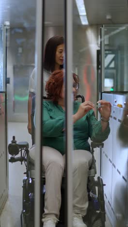 Woman in wheelchair being assisted at subway station