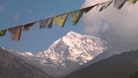 close-up-of-Nepali-prayer-flags-in-first-plane-and-a-big-snowy-mountain-in-the-background---Nepal