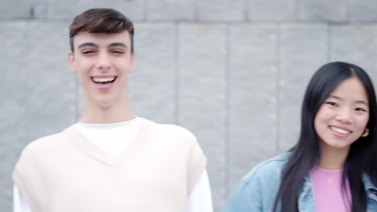 Happy friends laughing standing in the street