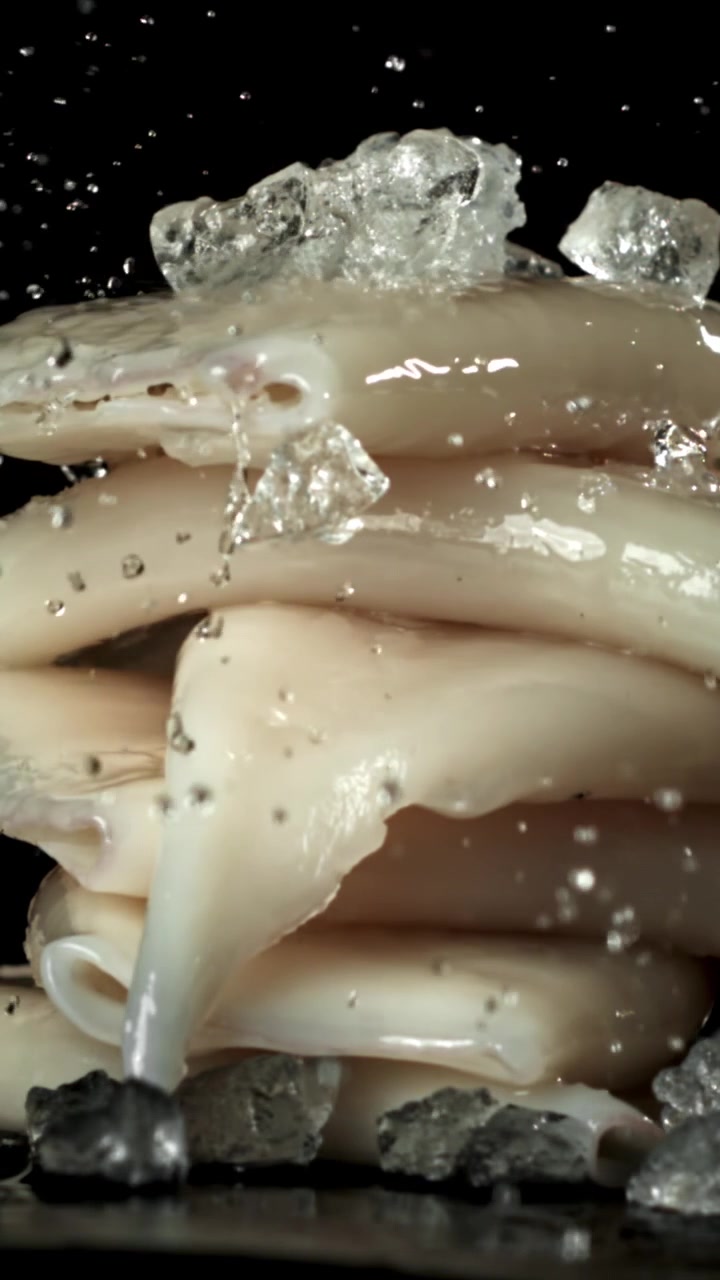 Acqua che schizza su calamari freschi e ghiaccio al rallentatore