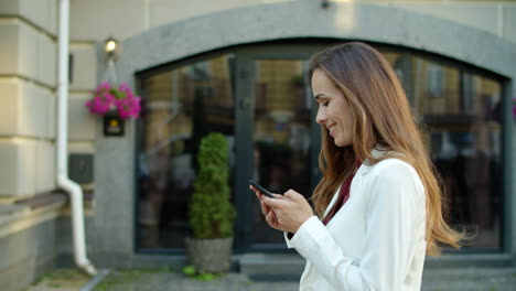 mujer de negocios usando el teléfono afuera. mujer feliz recibiendo buenas noticias afuera