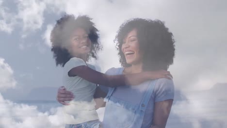 animation of smiling mixed race mother and daughter embracing over clouds