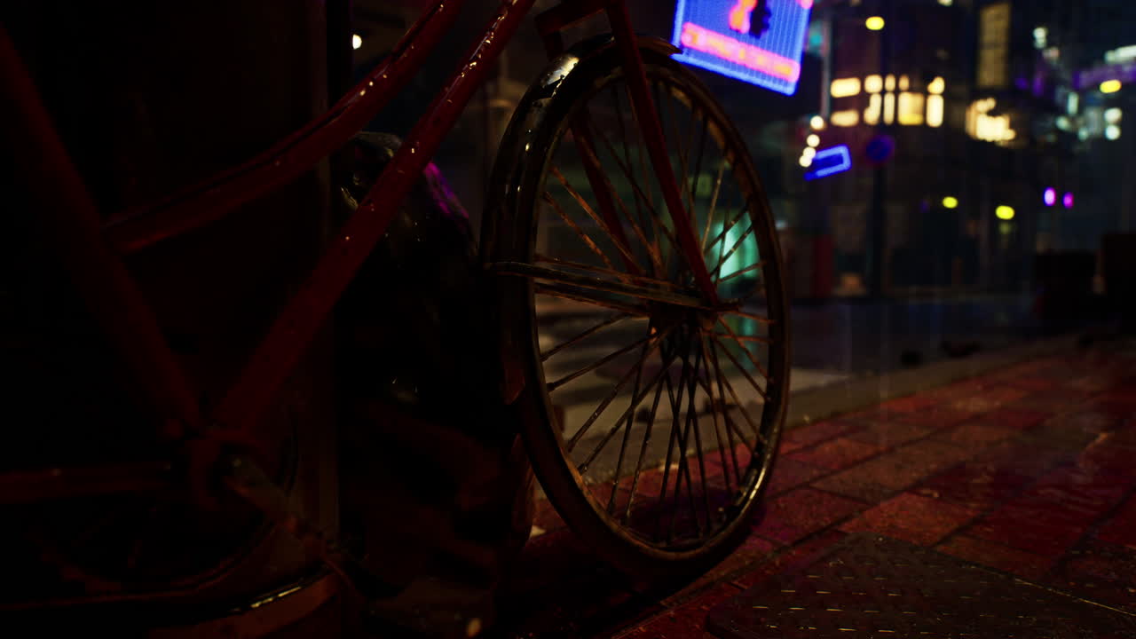 una bicicleta estacionada en una calle húmeda de la ciudad por la noche