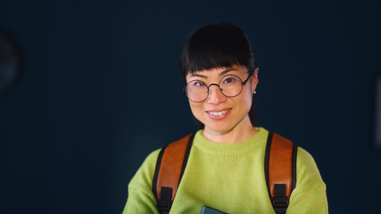 Smiling Young Woman Wearing Glasses and Backpack