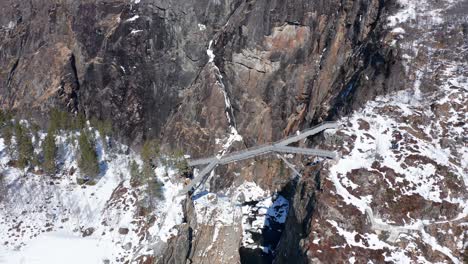 Spectacular-bridge-over-deep-canyon-near-Vøringsfossen-waterfall-at-Fossli---Winter-season-experience-with-no-tourists---Sunny-day-aerial