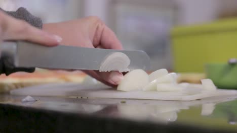 mujer joven cortando cebollas para sándwich a la barbacoa para el almuerzo