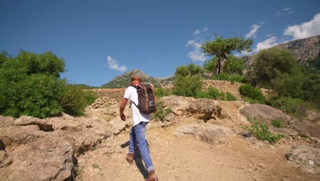 hombre anónimo caminando por la montaña