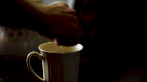 spoon inserted into a coffee cup stirred and removed
