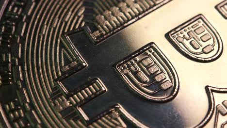 macro shot of crypto currency coin in bitcoin currency rotating slowly with reflective light