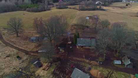 aerial drone, rural country houses landscape, excavator plows the soil, skyline