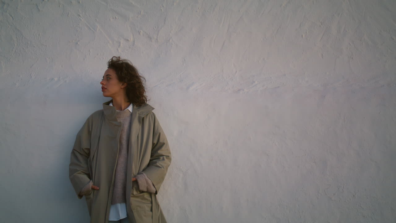 걱정하는 여자는 저녁에 거리의 벽을 수직으로 기울이고 생각하는 소녀는 혼자 습니다.