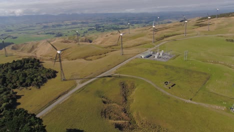 drone flying over wind farm area with mini substation below