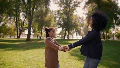 family playing in park holding hands. adorable smiling kid enjoy time with mom.