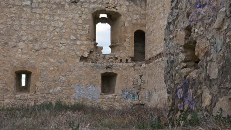 a monk walk in front the camera from right towards left in a ruined castle