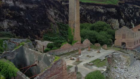 cinematic aerial shot flying towards the remains of the porth wen brickworks in anglesey, north wales, europe