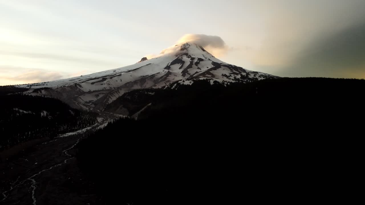 US, Oregon, Mt Hood, , 2025-05-10 - Drone view of Mt Hood in northern Oregon at sunset with clouds curling over the peak of the mountain in the Spring.