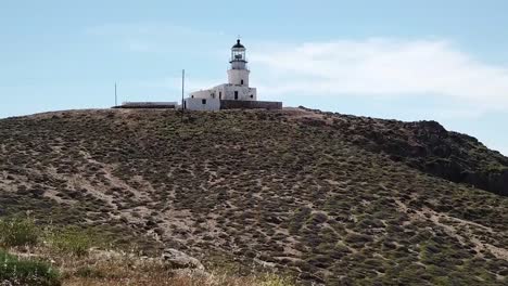 aerial drone moving forward with woman standing lighthouse