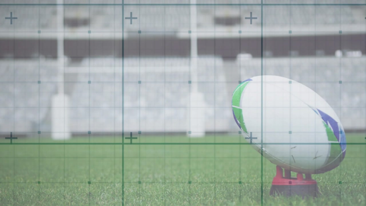 Rugby ball tip entering frame sliding rotating onto kicking tee under targeting grid for kick aim