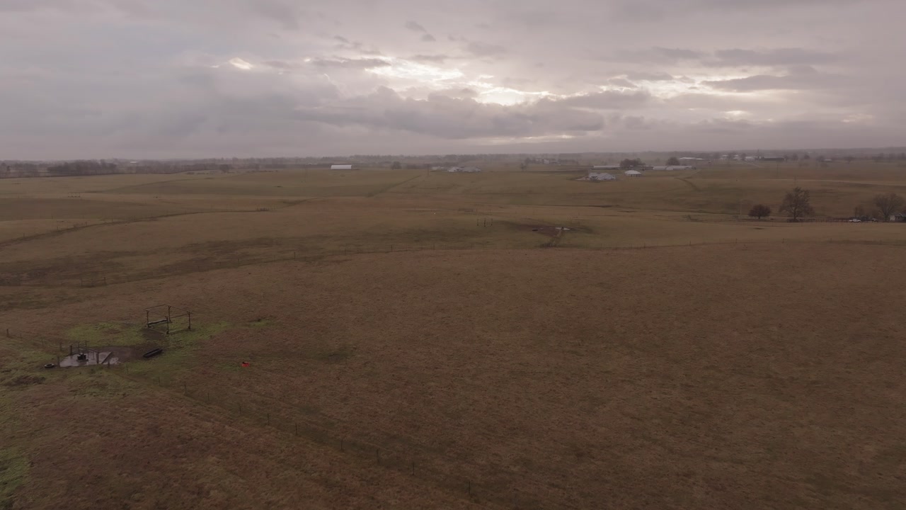 4k drone shot tracking through the Kentucky farmland on a cloudy day