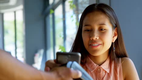 Teenage-girl-making-payment-through-NFC-4k