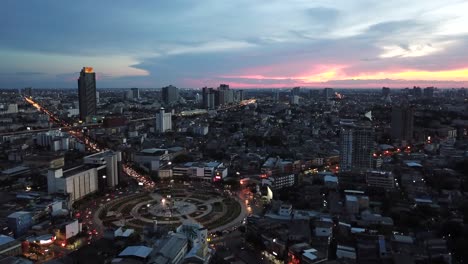 aerial view of city during sunset. flying over huge roundabout in bangkok, thailand