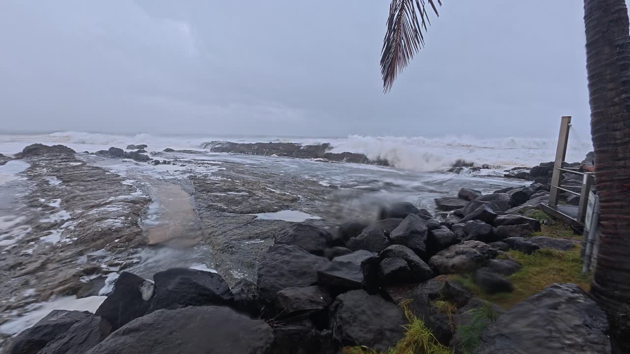 Powerful Waves Breaking On Shore Of Snapper Rocks In Gold Coast - Cyclone Alfred In Queensland, Australia. wide tilt-down shot